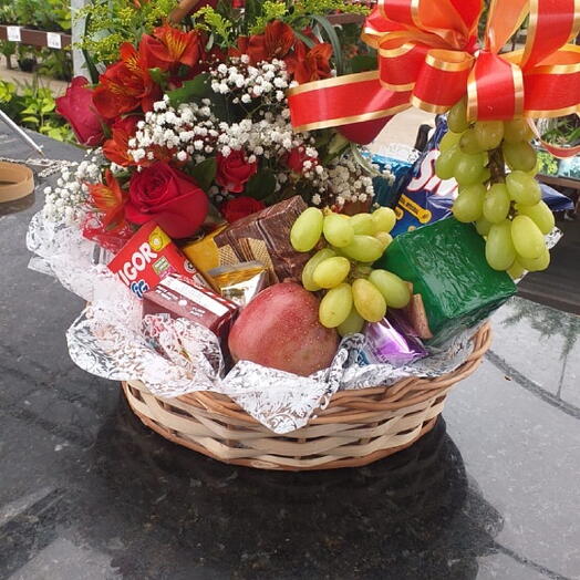 Cestas de goluseimas e frutas com arranjo de flores